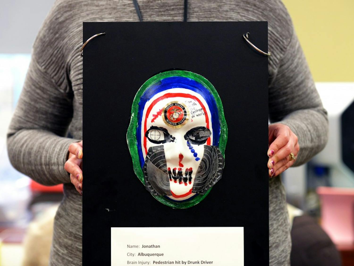 Janelle Torres-Groover holds one of the injury mask at the Center of Debilitation on Feb. 25, 2016. The mask are made as therapeutical tools; this mask was made by Jonathan, one of the patients in the center.