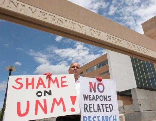 Walter Rohloff holds a sign in protest as the Year 5 Coalition pays a fine for property damage which occurred during protest over spring break. 