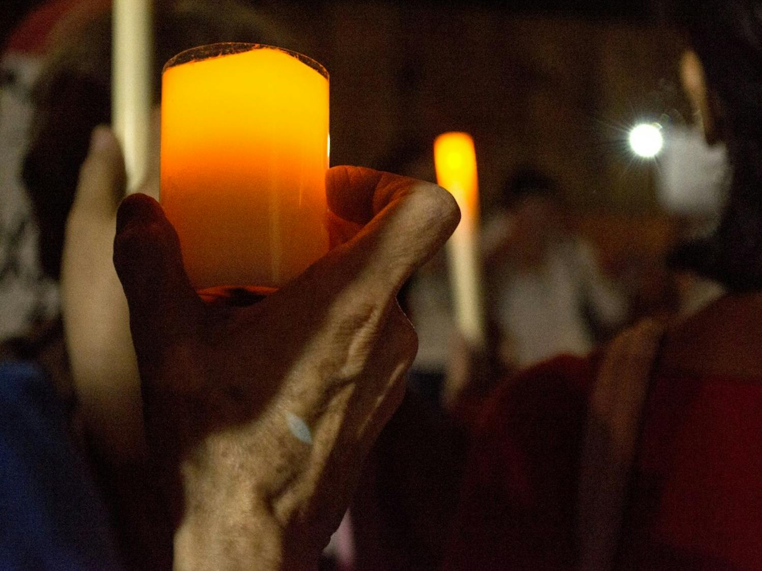 Attendees hold candles at an immigrant vigil held thursday night in Albuquerque’s Barelas community.
