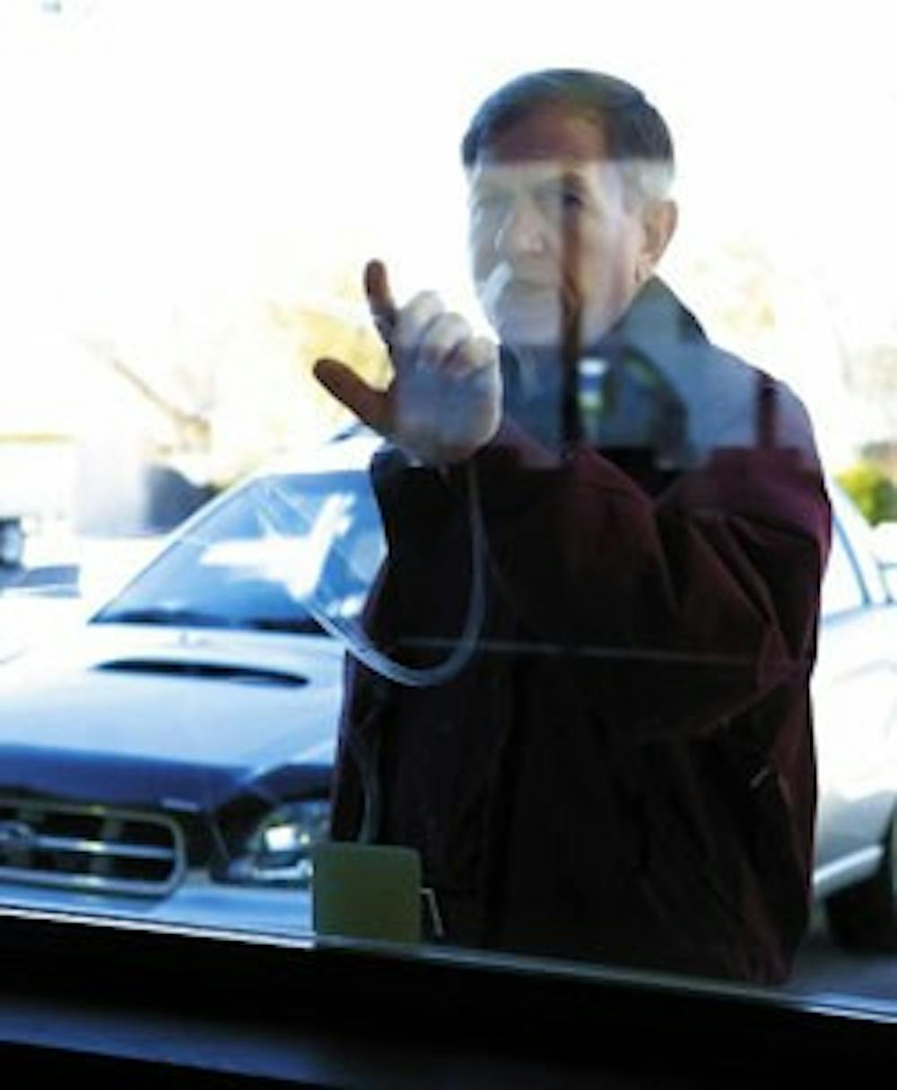 Morgan Patterson, director of community relations and development for the Salvation Army, looks at graffiti on a window outside of the donation drop-off on Central Avenue on Wednesday.  