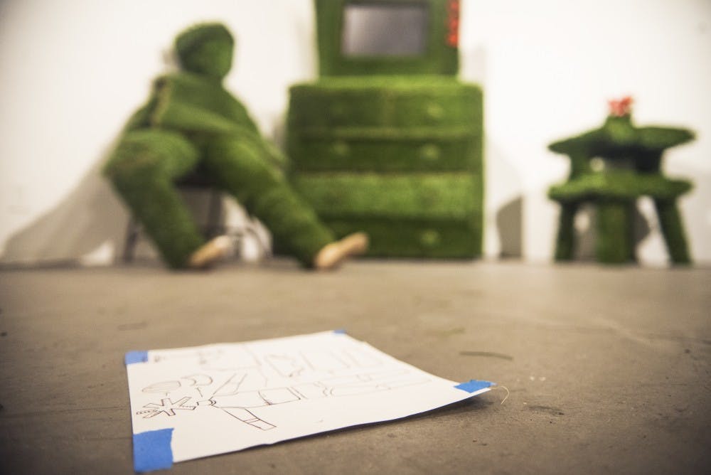 Plans for an artistic installation lie in front of the finished piece&nbsp;made by the GRAFT collective at a gallery Wednesday night.&nbsp;