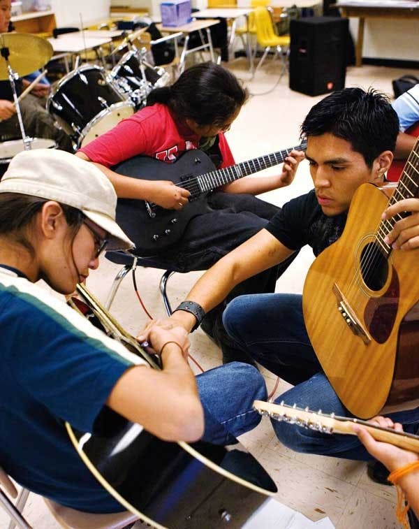 Student Darren Thompson, right, teaches guitar to Nez Evans during an after-school program at the Native American Community Academy on Tuesday.  Thompson is a member of the UNM Service Corps.
