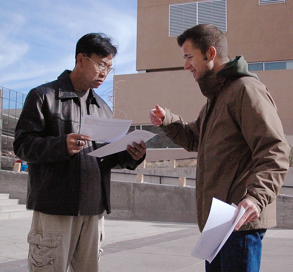 	Student Vitale Sparacello, right, speaks to Henry Nzuyen on Saturday near the Bookstore about the Italian citizens’ worldwide protest against Prime Minister Silvio Berlusconi. Sparacello accused the Prime Minister of controlling the media and leading with mafia-like policies. 