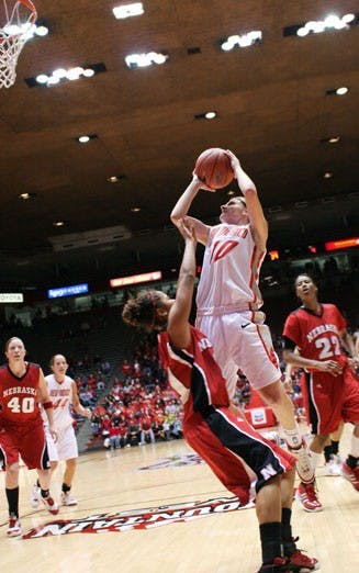 Amy Beggin rises above Nebraska's Nicole Neals in Saturday's 62-51 victory at The Pit. UNM won the Midtown Tournament, and Beggin was named MVP.