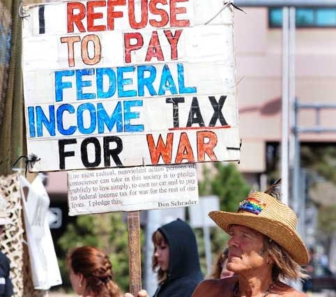 Don Schrader holds a sign protesting U.S. military operations during a rally at Galleria Plaza on Saturday.