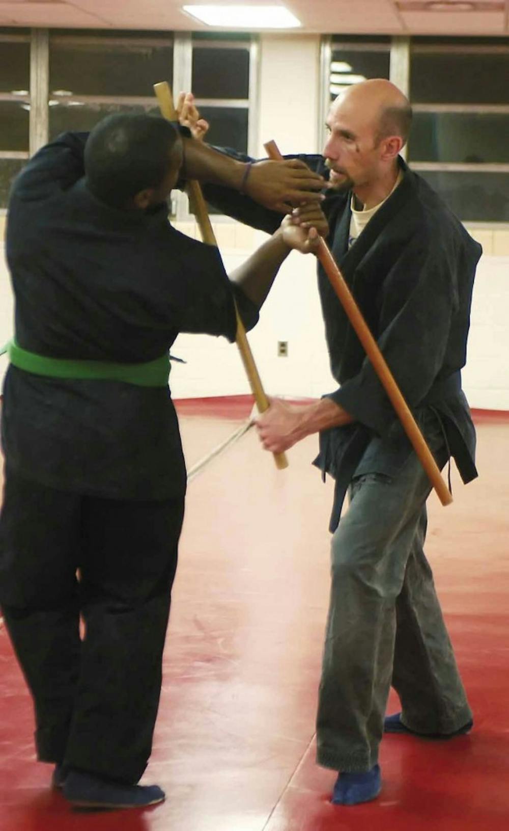 Robin Warne, right, teaches a ninjitsu self-defense technique with the help of Michal Feracho in Johnson Center on Monday. Recreational Services offered the class for free and will offer free classes all this week as part of March Madness Fitness Week. 