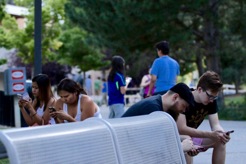 Mathew Bacon, right and&nbsp;Kevin Smith&nbsp;play Pokémon Go at UNM  in front of Zimmerman Library on Thursday, July 21, 2016. Main Campus is a popular spot for players to come and increase their rank in the game. 