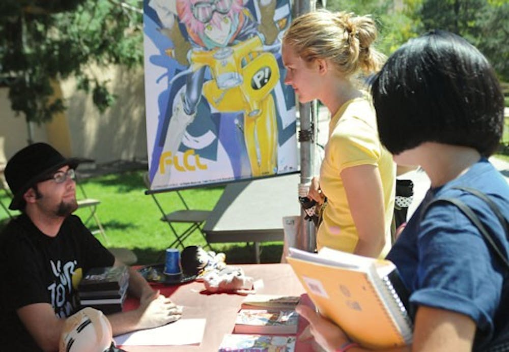 John Cairns tells Elyse Eversole, center, and Alison Trimmer about Anime Club at Welcome Back Days on Thursday.