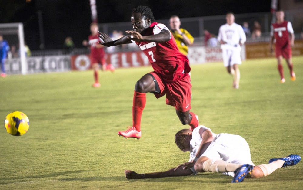 	New Mexico forward James Rogers leaps over midfielder Kortne Ford of Denver University during the Lobos’ final exhibition game on Saturday. The Lobos and Pioneers tied 1-1 in double overtime.