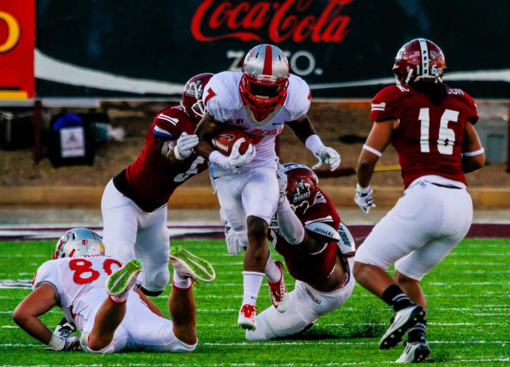 UNM running back Teriyon Gipson (7) runs through the middle of the NMSU defense during the Rio Grande Rivalry game Saturday night at Aggie Memorial Stadium in Las Cruces. The Lobos gained their first win of the season against the Aggies 38-35.