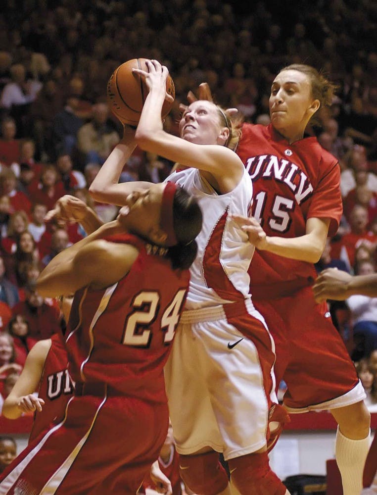 UNM guard Julie Briody, center, shoots while UNLV forward Faye Muller, right, tries to block her shot during Saturday's game at The Pit. The Lobos won 77-56.