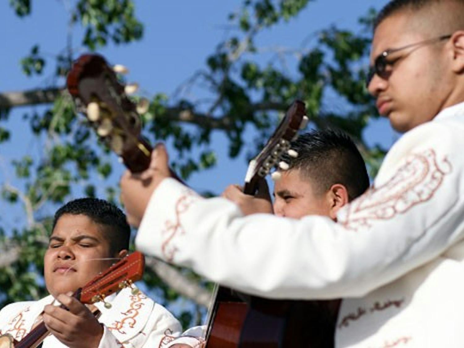 Mariachis Dorados de Villa perform during a May Day celebration at Tiguex Park on Thursday.