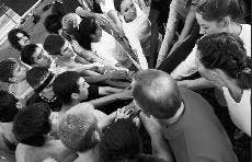 Cross country head coach Matt Henry leads a cheer after a Wednesday practice at Robertson Field.