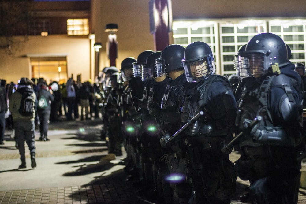 Police officers in riot gear stand in front of Smith Plaza on Friday, Jan. 27, 2017 at UNM Main Campus.