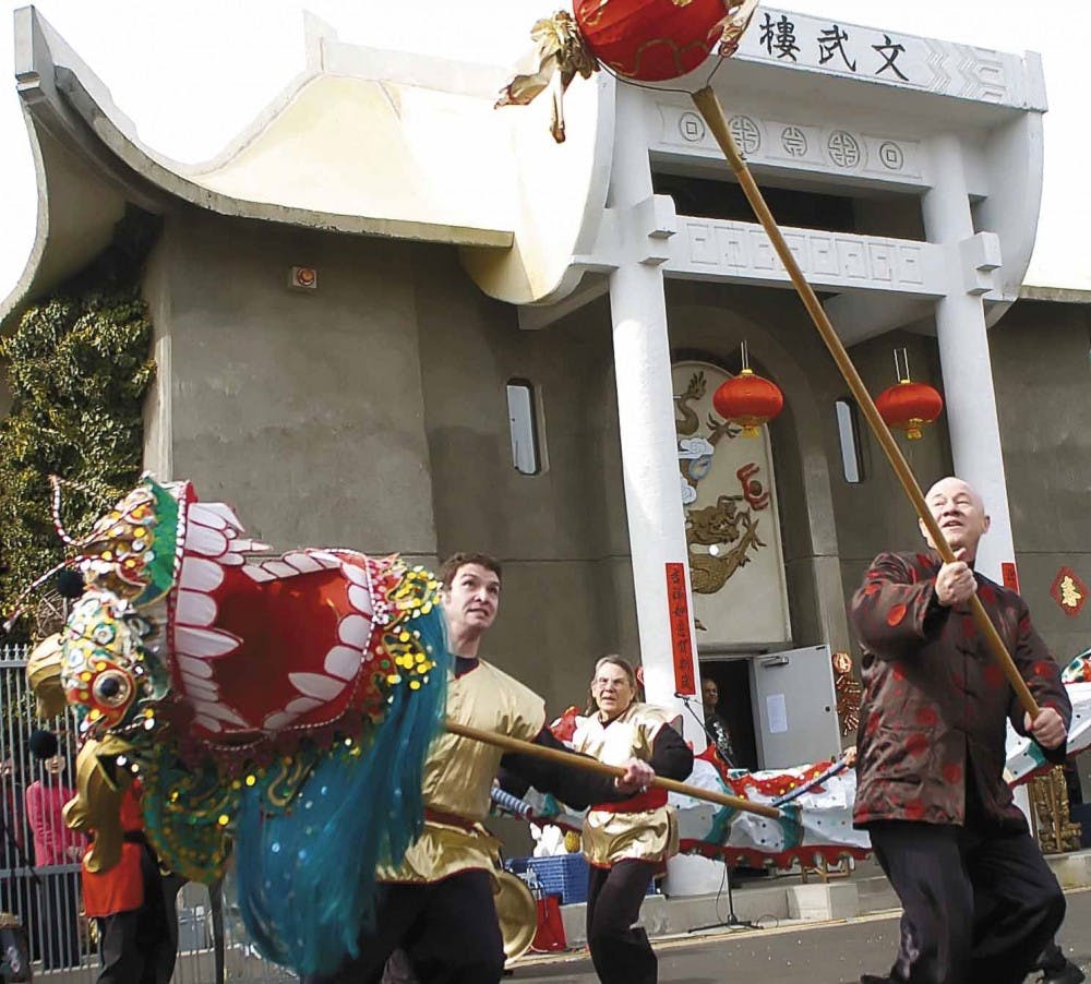 Chinese Cultural Center members Charlie Herbert, left, and Keith Winterkorn perform the Dance of the Dragon on Sunday at a Chinese New Year celebration at 427 Adams St. S.E.