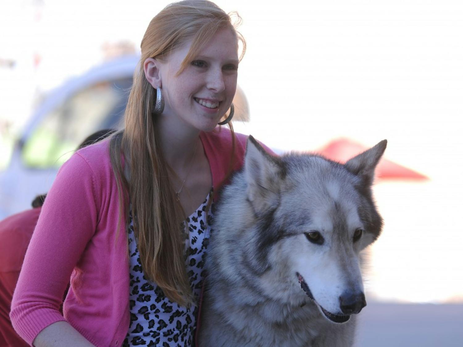 UNM student Devon Rosenkoetter poses with a wolf from the Wanagi Wolf Fund and Rescue at Smith Plaza last Friday. Only 58 Mexican gray wolves survive in the wild in the state, but the UNM Wilderness Alliance and Biology Undergraduate Society are trying to get the community involved in protecting the endangered species.
