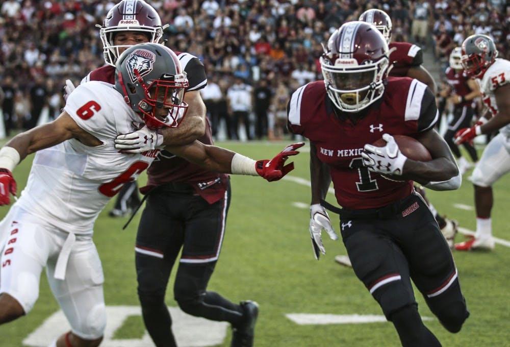 UNM’s De’John Rogers attempts to make a tackle on NMSU’s Jason Huntley. The Lobos defeated the Aggies 42-25 on Saturday night, breaking a two-year losing streak to their in-state rival.