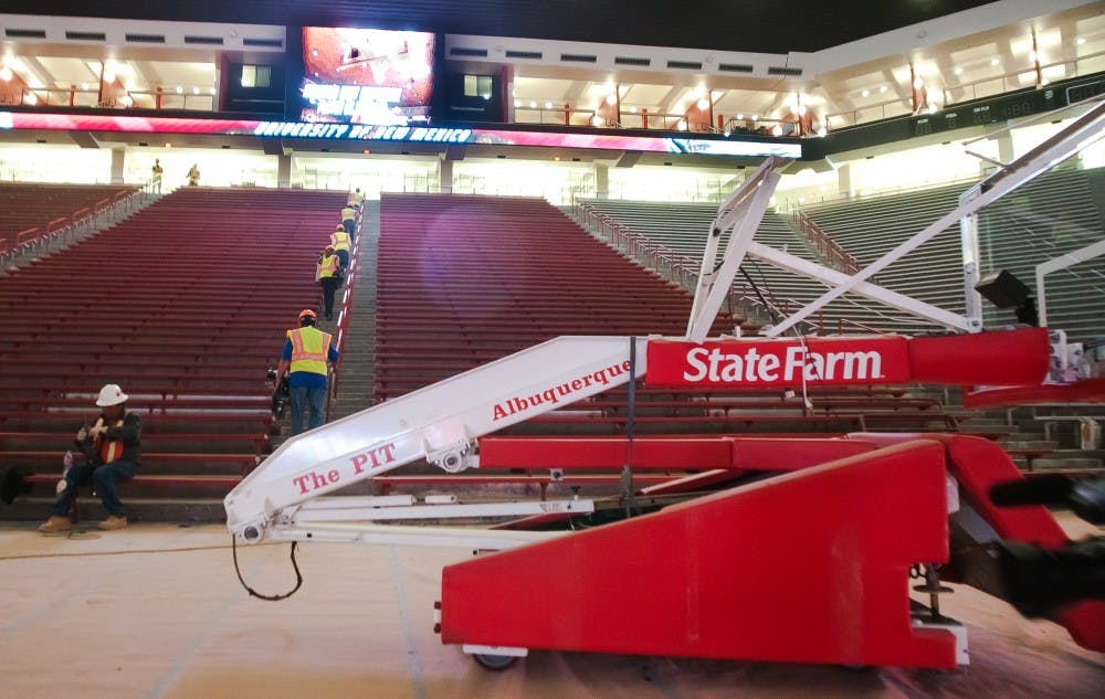 	Construction workers finish up final touches on The Pit. The renovated arena has 75, 000 square feet of new space with two new video boards on the north and south ends of the court. 
