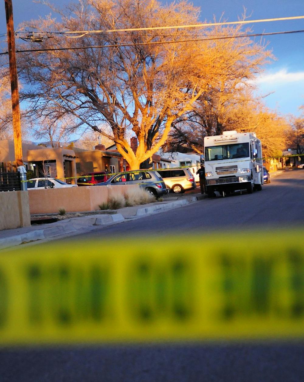	Police tape surrounds the house near campus where the man identified as the UNM professor and his girlfriend were found. Ralph Montoya, 37, is being held on two counts of murder.