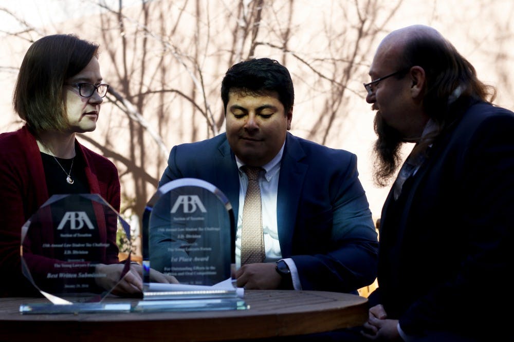 Mary Leto Pareja, Frank Cardeza and Scott Woody sit and discuss law cases outside the Law School Wednesday afternoon. The trophies presented were awarded to Woody and Cardeza for best overall and best written submission in the J.D. division of the 15th Annual ABA Law Student Tax Challenge.
