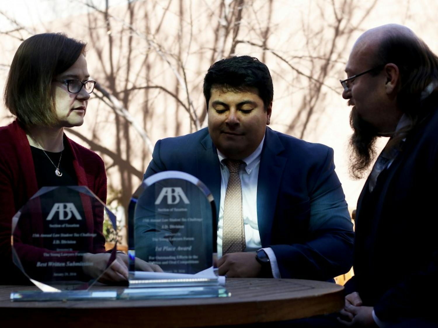 Mary Leto Pareja, Frank Cardeza and Scott Woody sit and discuss law cases outside the Law School Wednesday afternoon. The trophies presented were awarded to Woody and Cardeza for best overall and best written submission in the J.D. division of the 15th Annual ABA Law Student Tax Challenge.