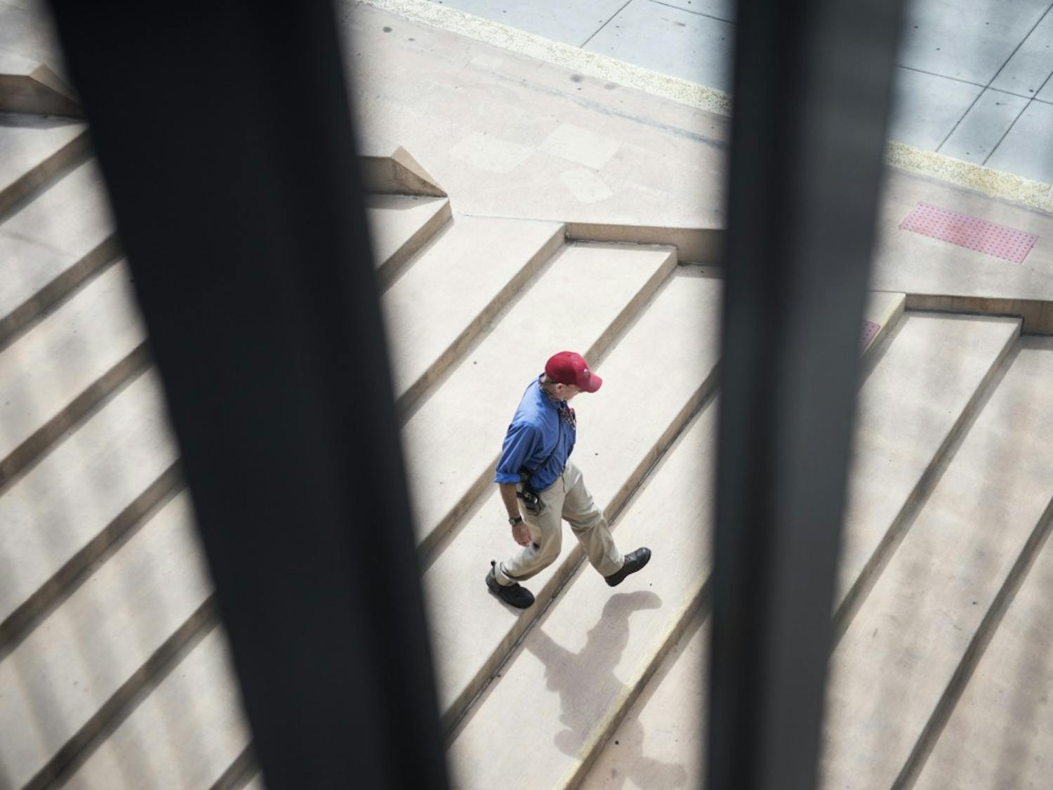 A UNM PATS parking enforcer walks down the steps of the Cornell Garage Thursday afternoon. On Aug. 10, 2015 PATS initiated a new half hour paid parking rate that begins at $1.00 per half hour. 