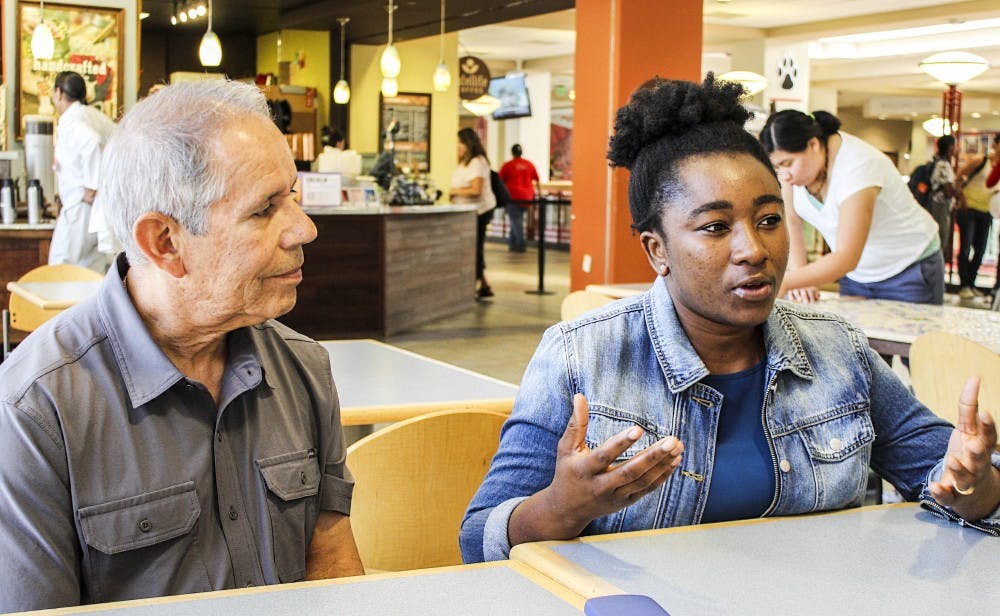 Mark Narvaez, left, and Theresah Napetey, right, discuss the many positive experiences they have had with ?Project for New Mexico Graduates of Color,? also known as PNMGC. PNMGC aims to build a community with underrepresented student groups at UNM.