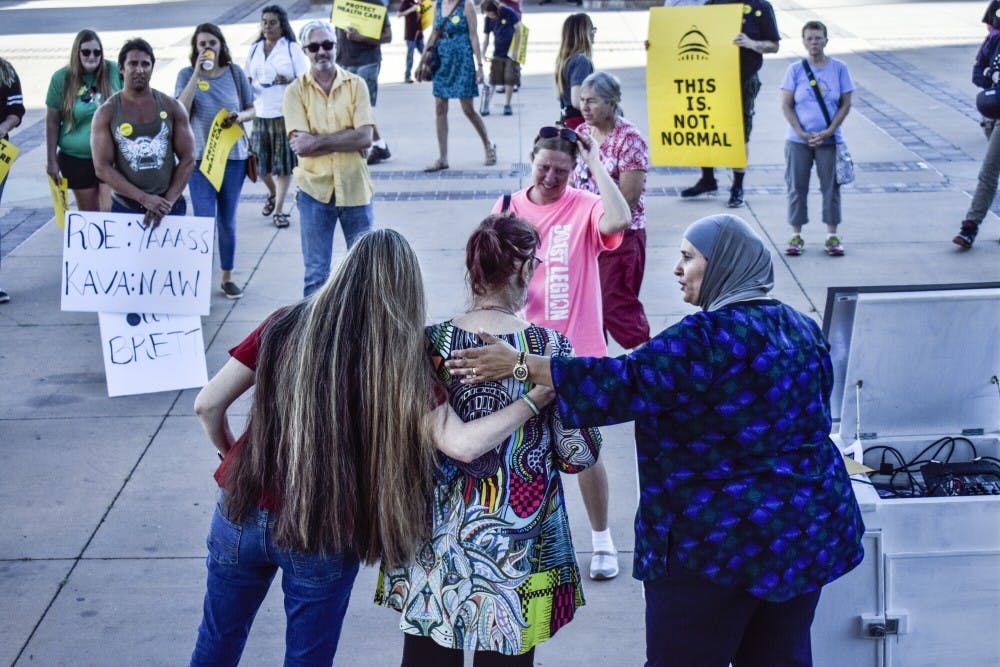 Protest organizers hug a woman who shared her story of sexual assault at the anti-Kavanaugh demonstration on Friday, Sept. 28, 2018.