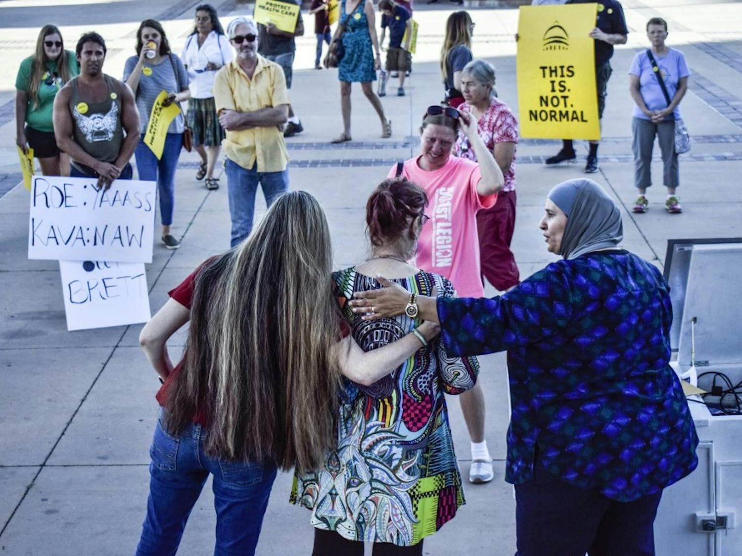 Protest organizers hug a woman who shared her story of sexual assault at the anti-Kavanaugh demonstration on Friday, Sept. 28, 2018.