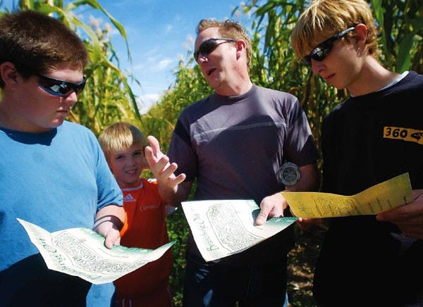 Steve Earley, center, and his sons, from left, Alex, Zach and Tyler, look over a map of the Maize Maze at the Los Poblanos Fields Open Space near Monta
