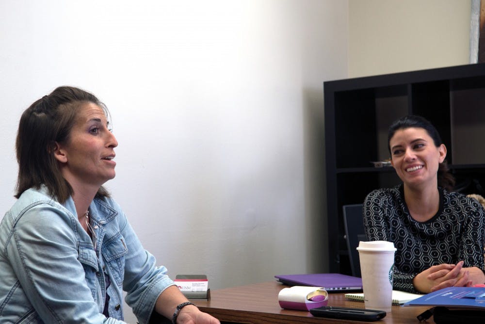 Tenured track assistant professors Melina Vizcaino (left) and Bernadine Hernandez discuss the selection of Anne Hillerman for the 2015 Rudolfo and Patricia Anaya lecture. The lecture will take place Thursday, Oct. 22.
