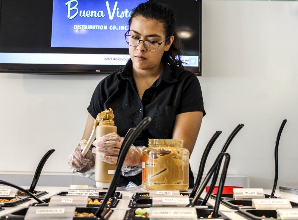 UNM student Sofia Lucero refills flavor toppings Saturday afternoon at Olo Yogurt Studio in Nob Hill. Olo was founded by a UNM alumna. The yogurt studio currently features 10 different flavors and an array of toppings. 