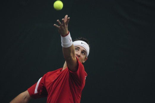 Johnny Parkes serves during Sunday's match against Indiana. Parkes won his singles match, and the Lobos rolled, 4-3.