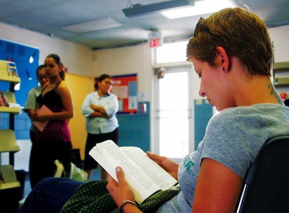 Student Mindi Kaiser reads in the waiting room at the Stanford Public Health Office. "I come here to get yearly checkups," Kaiser said. "It's easy, especially when you don't have health insurance."