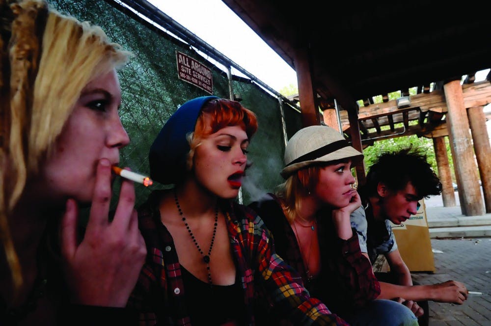 	From left to right:  Katy Seiler, Myriah Otero, Sonora Werenko and Forest Sumrald smoke cigarettes while waiting for the UNM shuttle on Redondo Drive and Yale Boulevard. UNM’s smoke-free policy has gone largely unenforced. 
