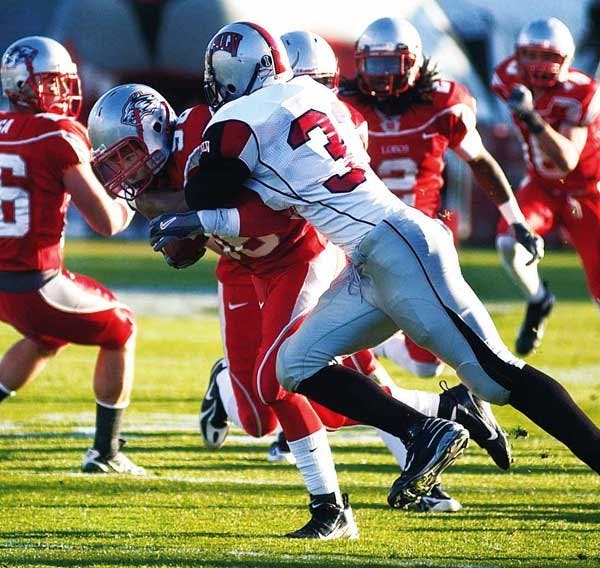 UNM punt returner Frankie Solomon gets tackled by UNLV linebacker Jason Beauchamp during Saturday's 27-6 win at University Stadium.