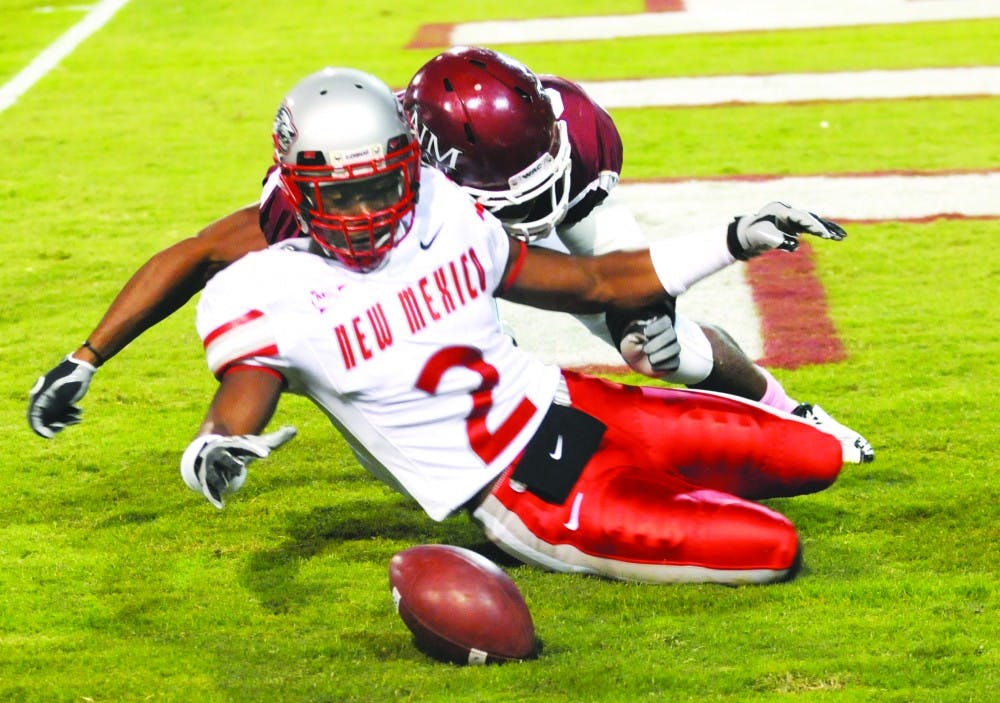 	NMSU quarterback Tanner Rust evades a UNM defender in the first quarter of Saturday’s Rio Grande Rivalry game at Aggie Memorial Stadium. The Aggies defeated the Lobos 16-14. 