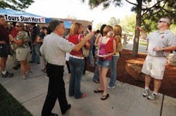 Rob Burford, right, and Dean of Students Randy Boeglin help students and their parents find their guides for campus tours Sunday at the Duck Pond.