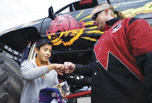 Charles Benns, right, talks to 10-year-old Luis Arzate outside of Carrie Tingley Hospital on Tuesday. Benns owns and races his monster truck, "Pit-bull," to raise money for the hospital.