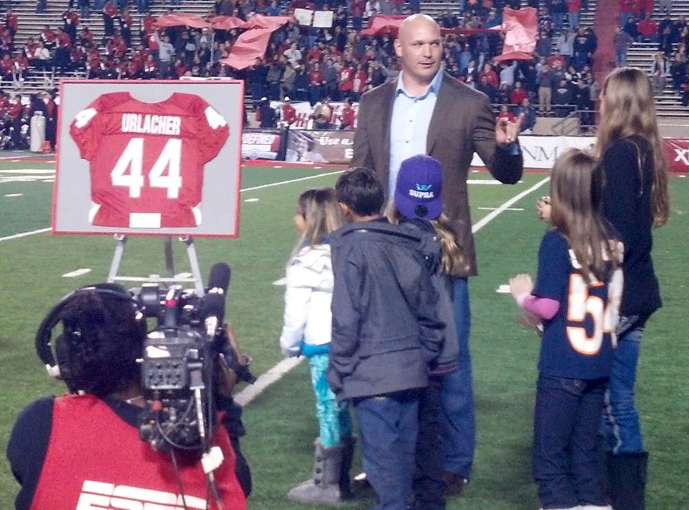 	Former New Mexico Lobo and Chicago Bear linebacker Brian Urlacher flashes the “woof, woof, woof” hand signal after the University retired his number Friday night at University Stadium.