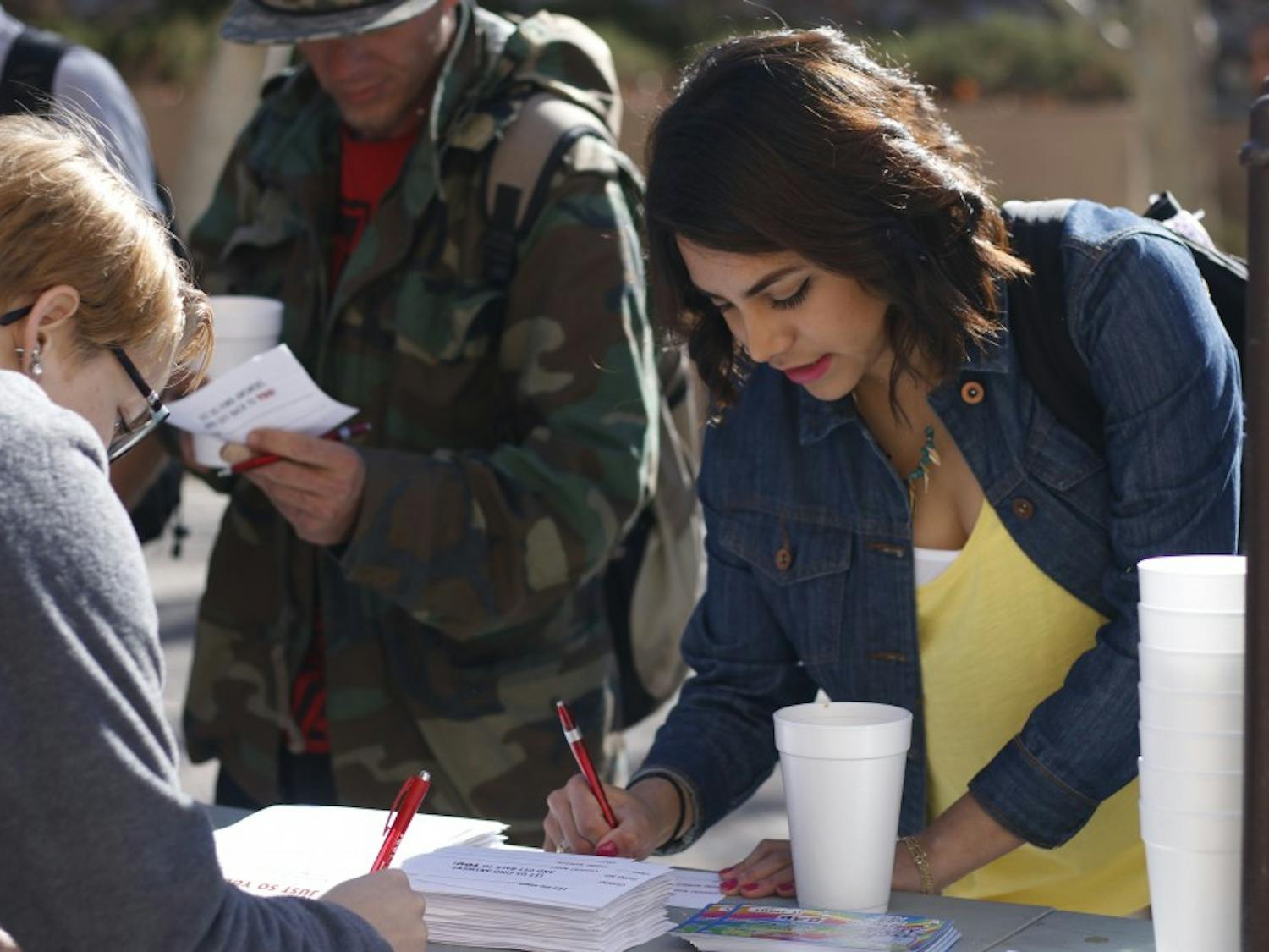 Grisell Garcia signs up for the ASUNM initiative that will reach out for comuter students on Feb. 29, 2016 by the south lot shuttle stop area. ASUNM students give out free donuts and coffee.