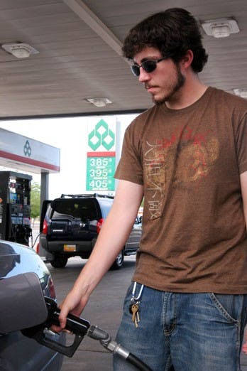 Junior Matt Martin fills up at a gas station near campus. In response to rising fuel prices, UNM is piloting a four-day workweek program that aims to cut University workers' commuting costs. 