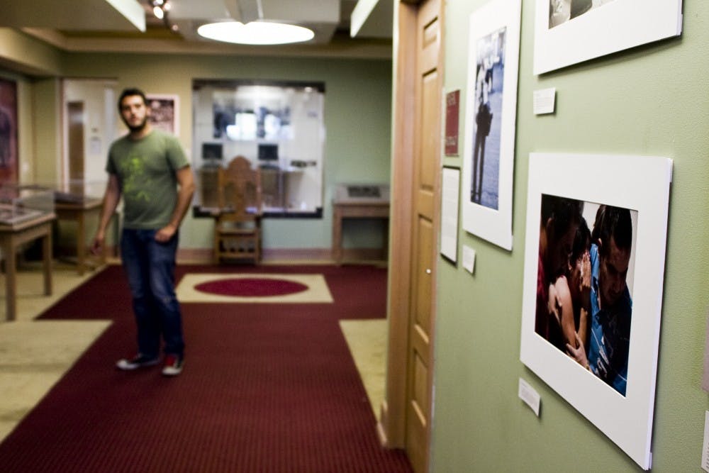 	Curator Mike Graham looks over of “Grass Roots Narratives in Oaxaca and Cuidad Juarez,” the collection mounted in the second floor of Zimmerman Library. The exhibit depicts strong images of the troubled Mexican region and efforts of its citizens to temper the violence. 