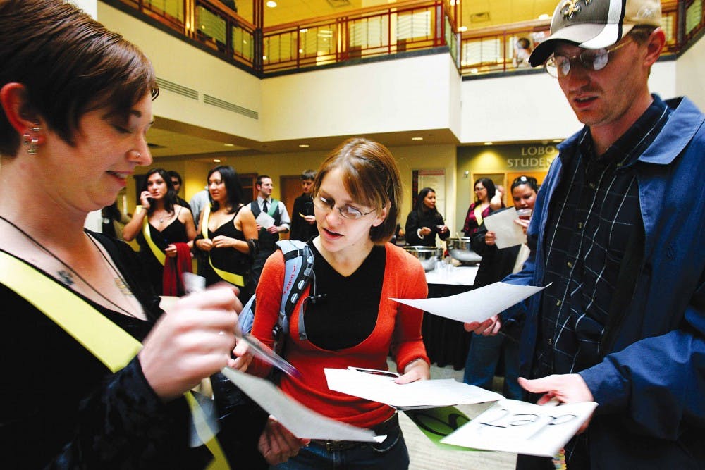 Evelyn Aschenbrenner, left, gets ready to be auctioned off, while Shelly Karlin and Will Brenneman wait for the Society of Women Engineers date auction to start in the SUB Atrium on Friday.