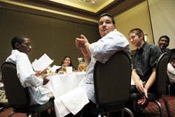 Students from the L.A. Works program, from left, Joseph Martinez, Miguel Gonzalez and Jeremiah Brady, applaud as the program's founder, Sal Velasquez, finishes a speech during the program's graduation ceremony at the SUB on July 28.