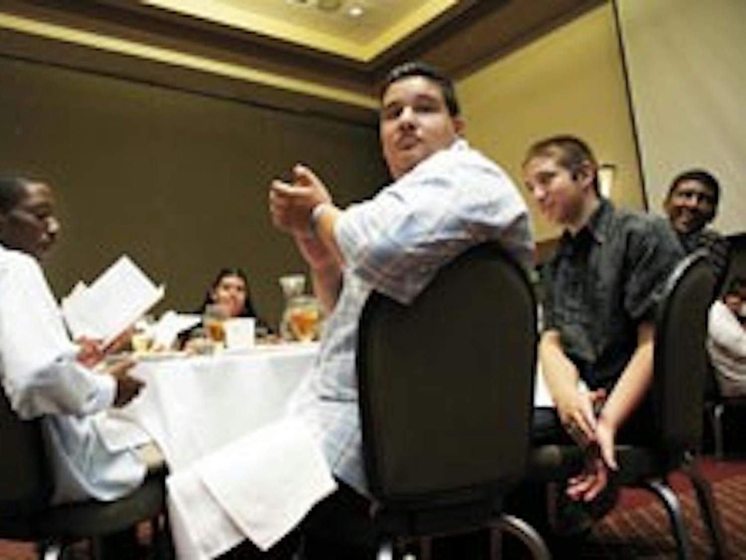 Students from the L.A. Works program, from left, Joseph Martinez, Miguel Gonzalez and Jeremiah Brady, applaud as the program's founder, Sal Velasquez, finishes a speech during the program's graduation ceremony at the SUB on July 28.