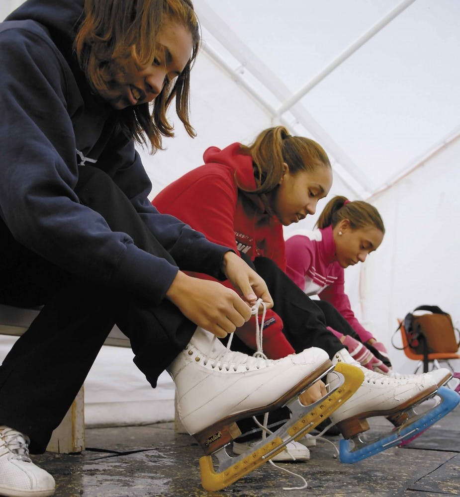 Student regent Dahlia Dorman, center, laces up her skates with her sisters Dohnia, left, and Darcey on Saturday at the Outpost Ice Arena on Tramway Boulevard. Although Dorman doesn't compete anymore, she still enjoys figure skating with her sisters.    
