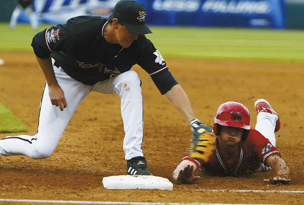 UNM's Jordan Pacheco is tagged out by Todd Sears of the Albuquerque Isotopes after leading off first base during Tuesday's game at Isotopes Park. The Lobos lost 7-2. 