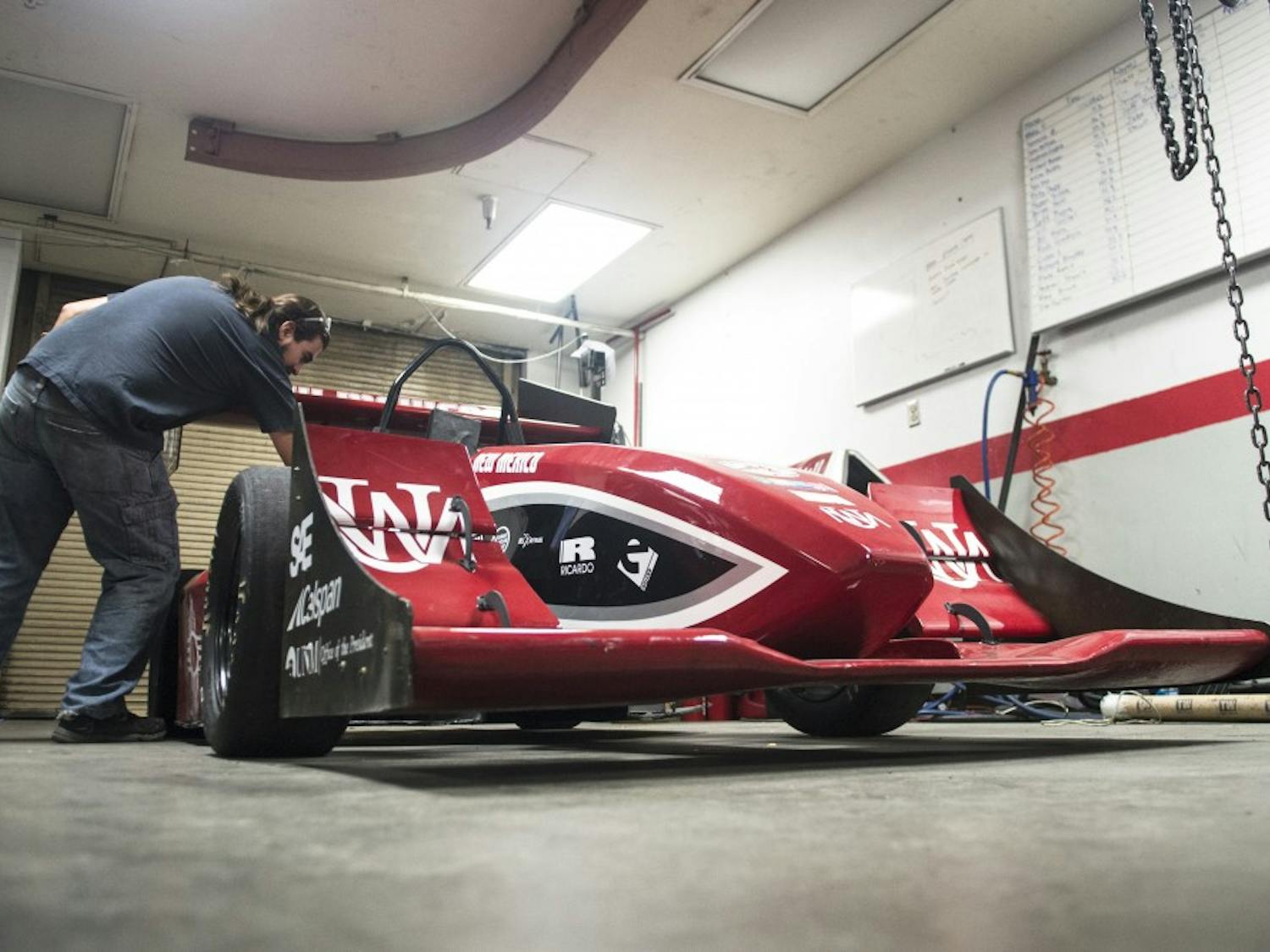 Estevan Pina, a senior mechanical engineering student, reaches into UNM’s Formula SAE motorsports program 2014 car on Nov. 14. The program has been ranked No. 5 in the country and No. 18 in the world, according to a poll issued by the Formula Student Combustion World Rankings.