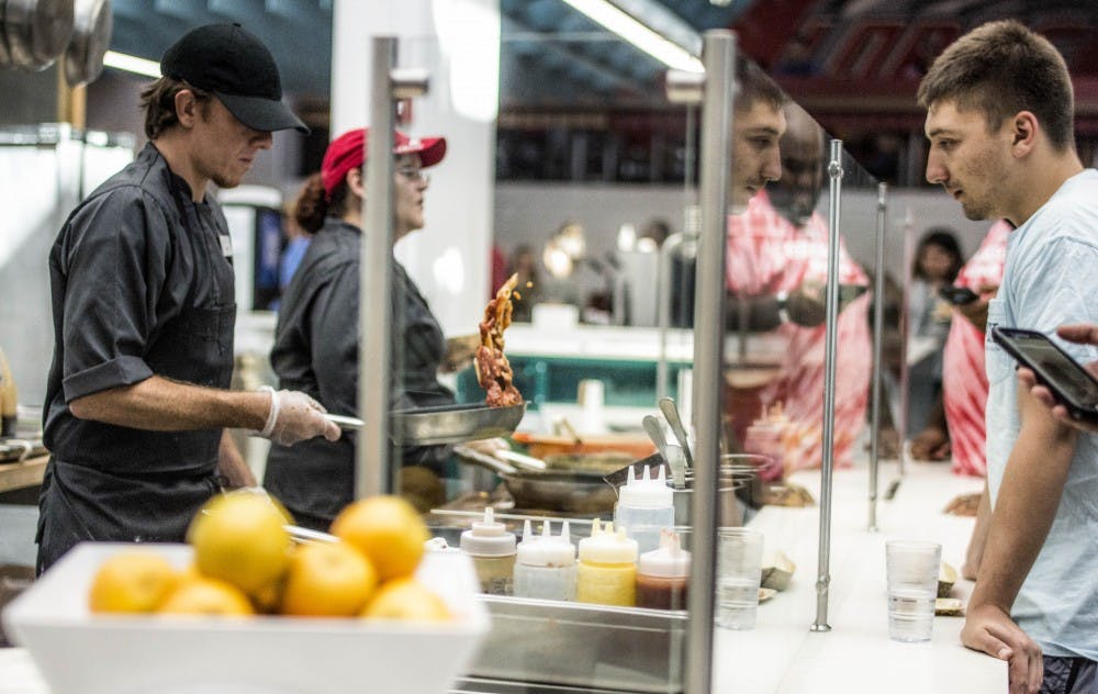 Right, Brandon Lee, watches, Left, Chef James Dean Stewart toss a pasta marinara dish during the grand opening of the renovated La Posada Dining Hall on Wednesday August 30th, 2017.